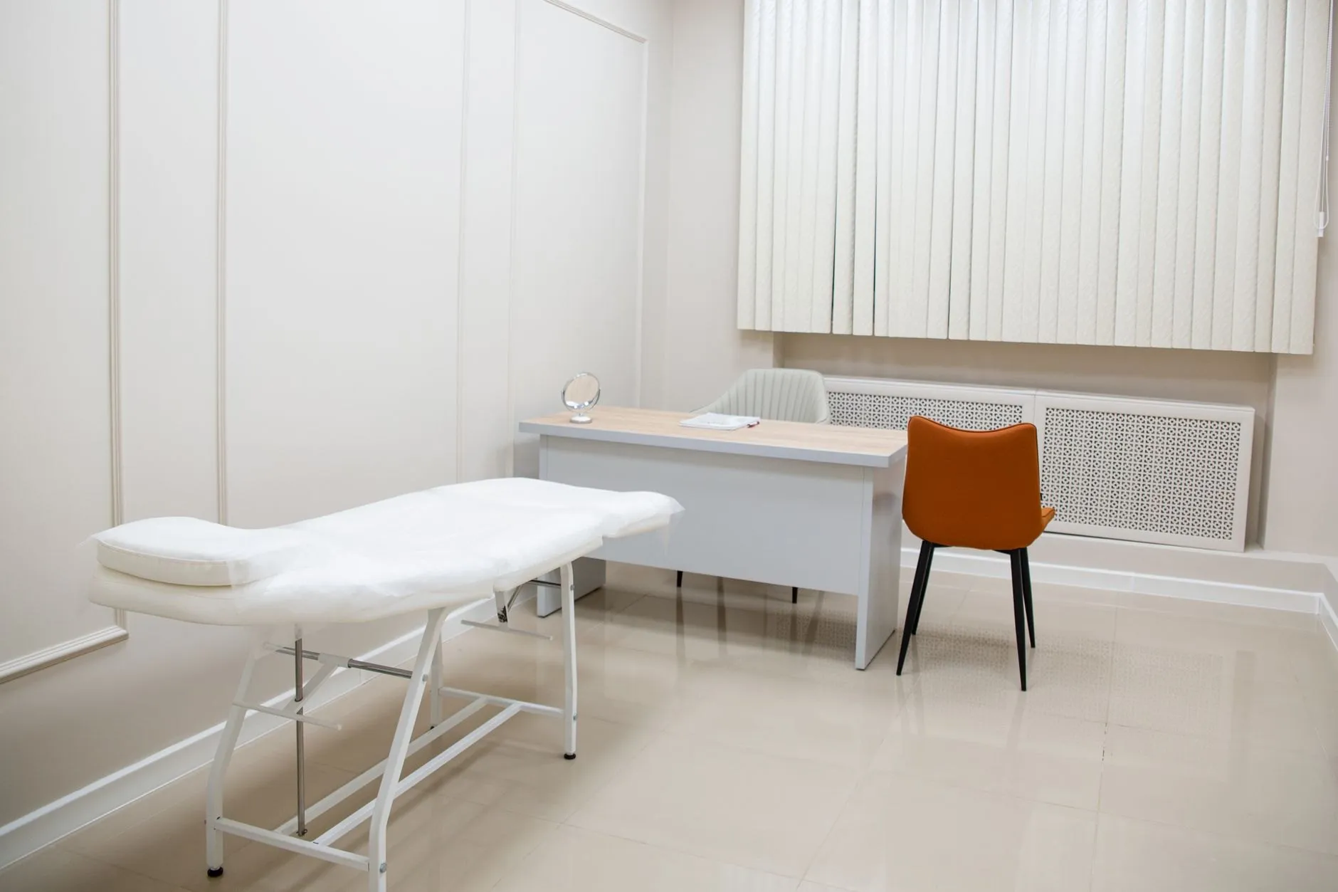 A calm, minimal aesthetic clinic treatment room in soft natural light
