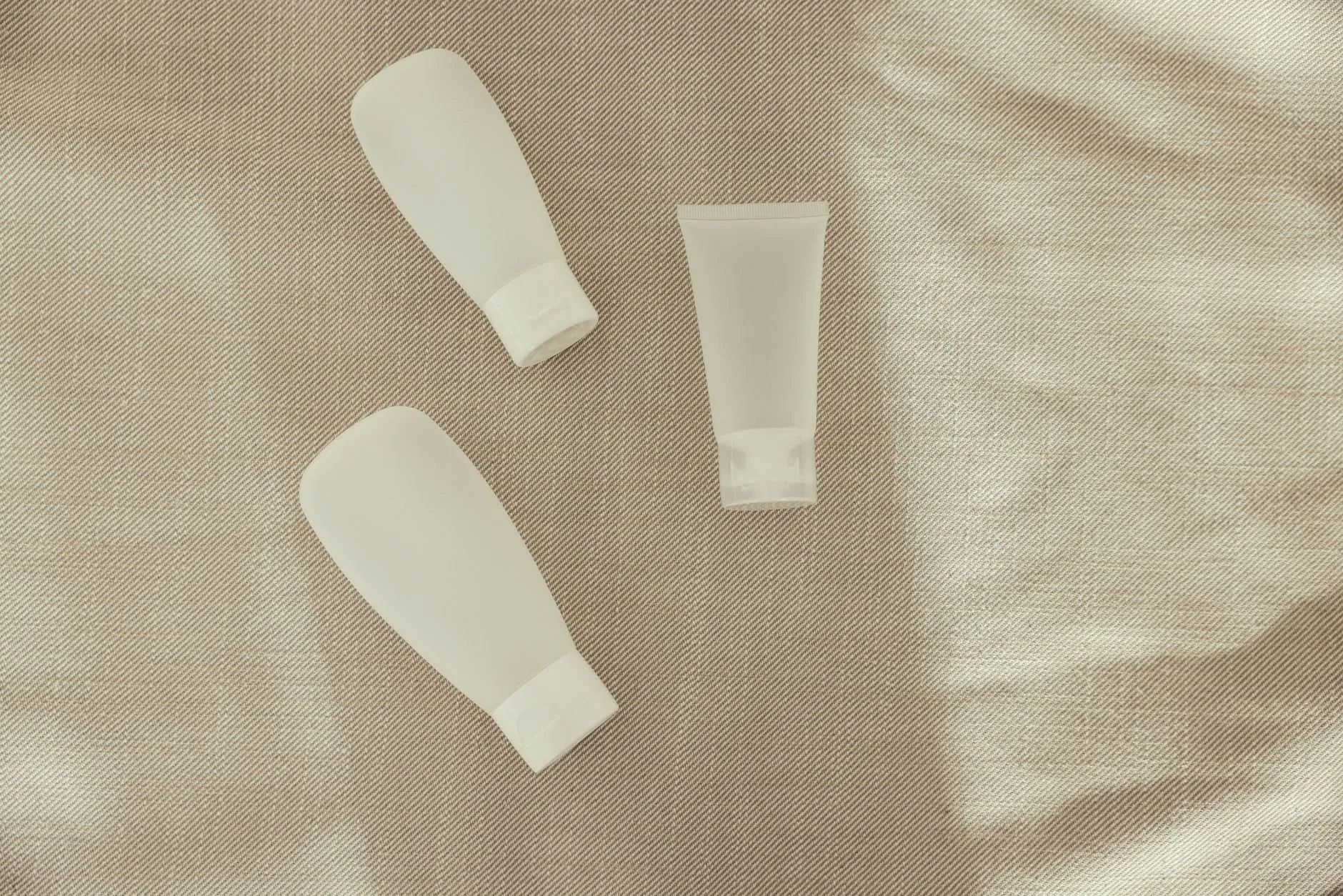 Soft, sunlit minimal skincare still life in warm neutral tones